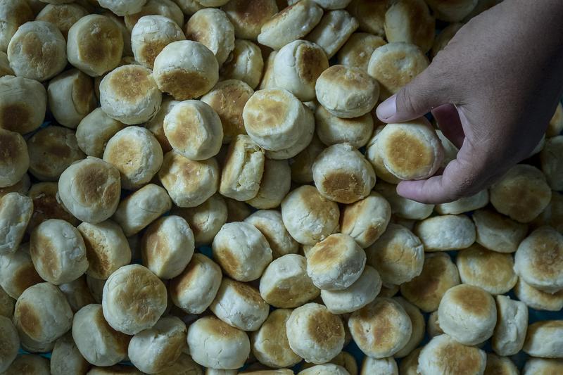 Pekerja memegang bakpia sebelum dikemas di sentra produksi Bakpia Kampung Pathuk, Daerah Istimewa Yogyakarta, yang dikenal sebagai ikon kuliner khas Yogyakarta.