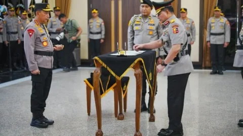 Kapolri Jenderal Polisi Listyo Sigit Prabowo berdiri di sebelah kiri saat Irjen Pol. Roycke Harry Langie menandatangani dokumen serah terima jabatan di Mabes Polri.