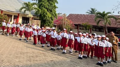 Siswa SD berseragam merah putih mengikuti upacara bendera di sekolah, ilustrasi terkait Program Indonesia Pintar (PIP) 2026.